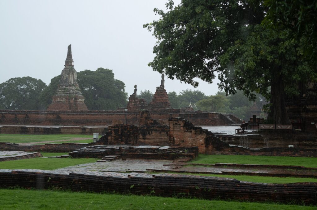 Ayutthaya: come arrivare da Bangkok, cosa visitare e dove dormire Serene view of ancient temple ruins in Thailand during rainfall.