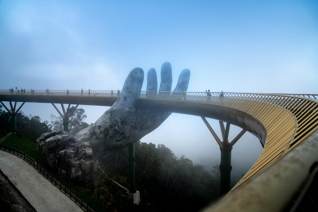 Quando Andare In Thailandia il Periodo Migliore Golden Bridge in Vietnam with its iconic hand sculpture enveloped in foggy ambiance.