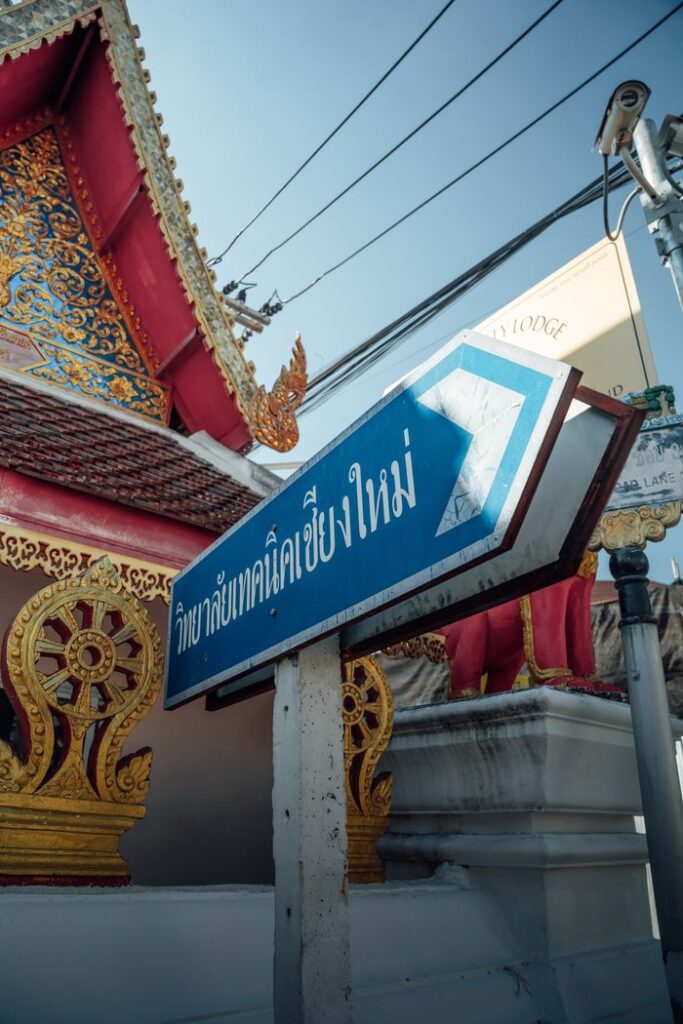 Traditional Thai architecture and a directional sign in Chiang Mai, Thailand.